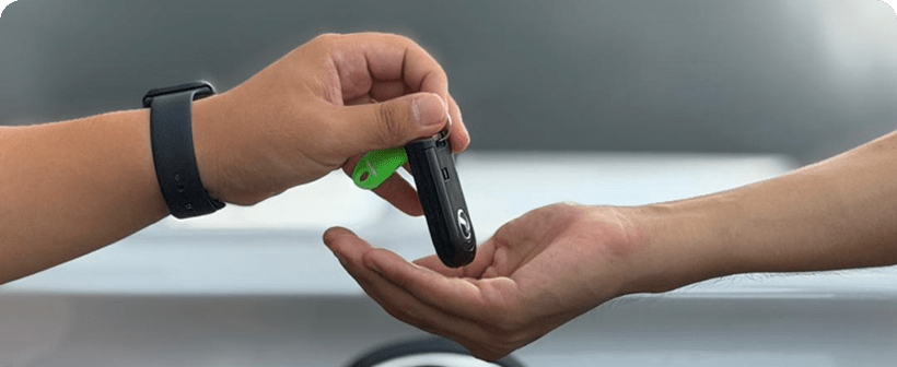 Handing over a car key to a customer.